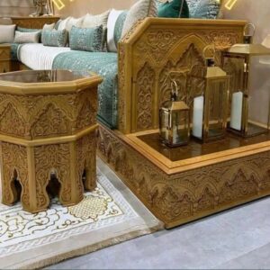 Salon élégant et lumineux avec canapés beiges, table basse centrale et grand lustre doré.