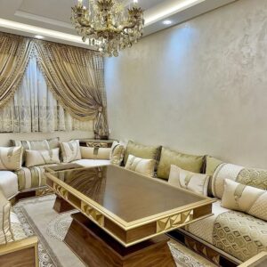 Salon marocain luxueux avec canapé beige, rideaux élégants et lustre doré traditionnel.